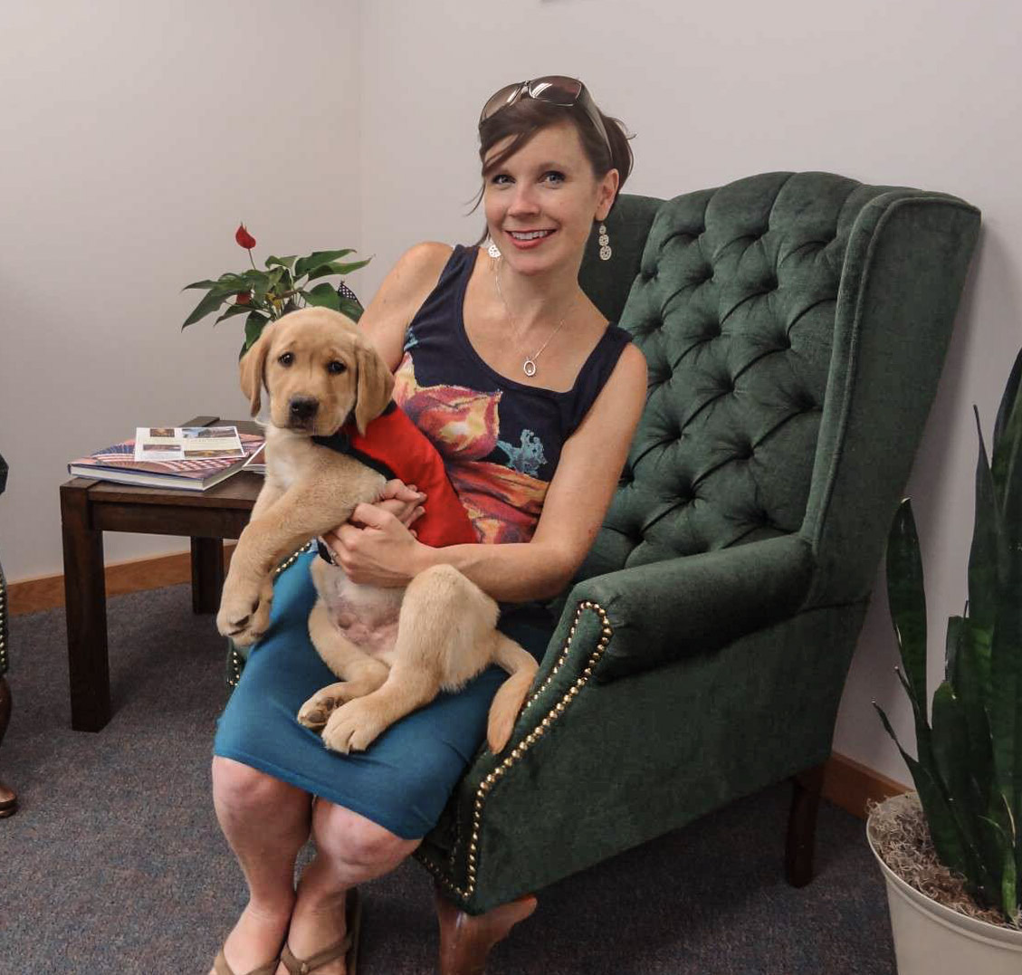 Joy Smith holding a Kingridge Labrador therapy puppy